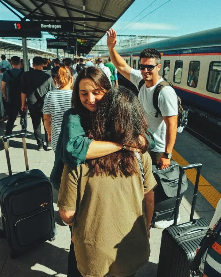 Viajeros reencontrándose en una estación de tren